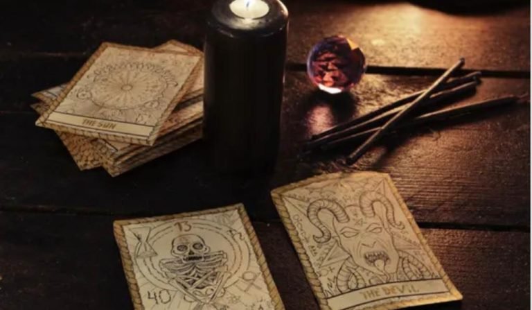 A black candle and some scary looking tarot cards